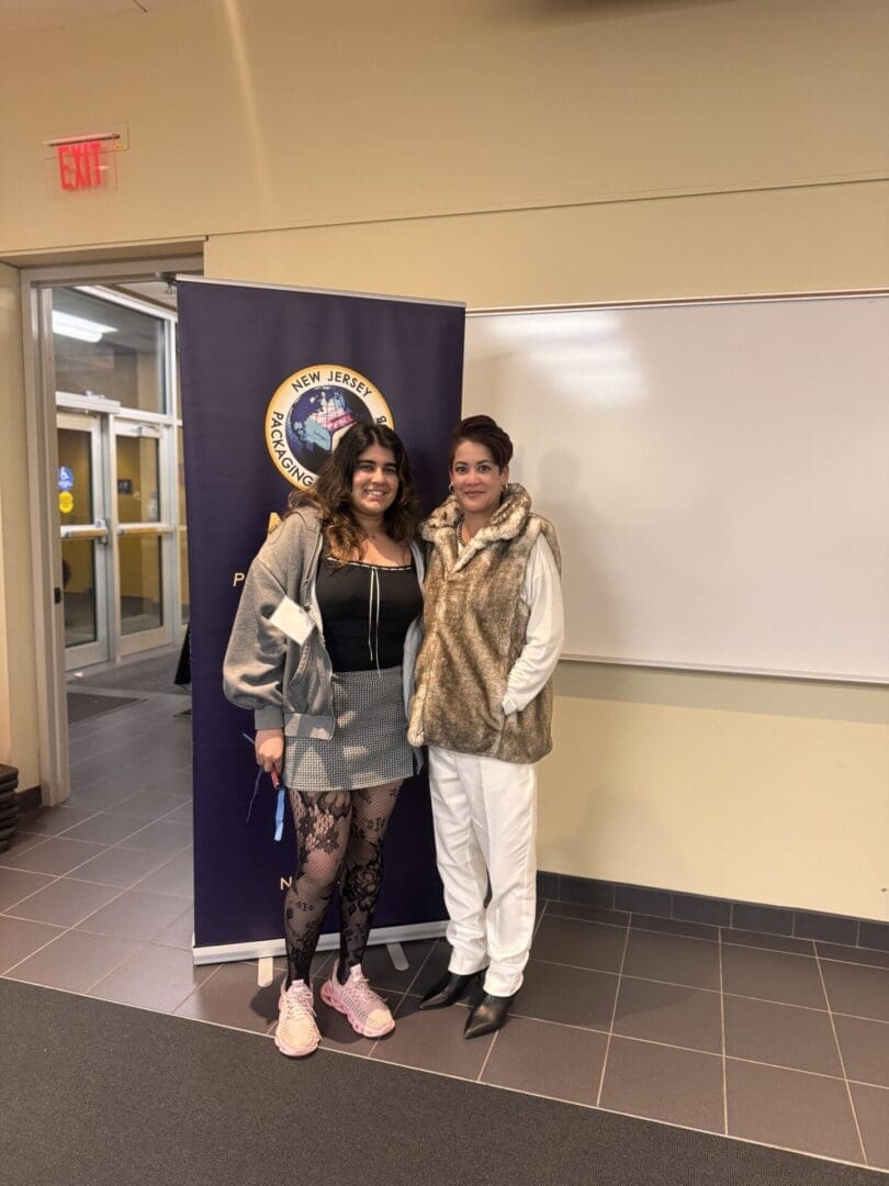 Two women standing in a classroom.