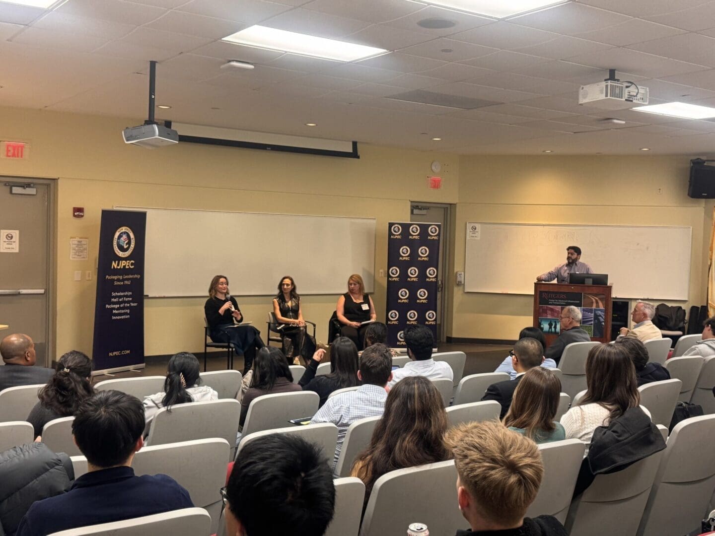 A panel discussion in a lecture hall with three women seated on stage