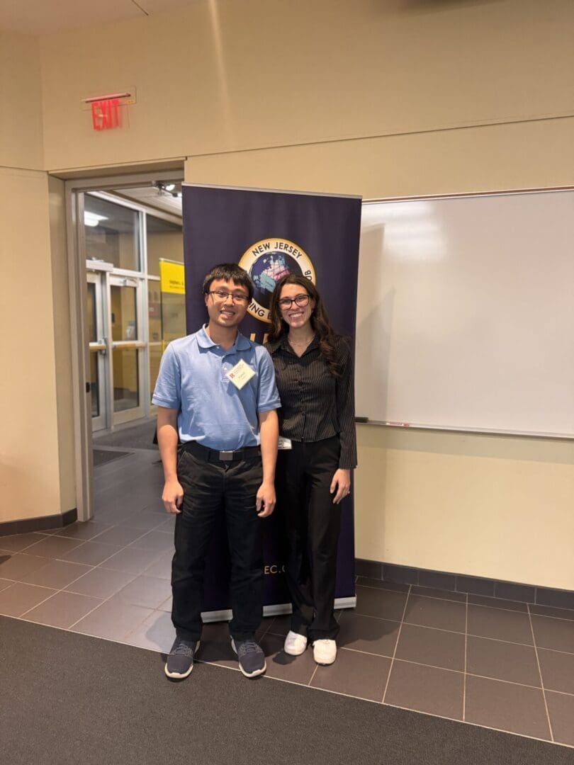 Two people standing in a hallway.